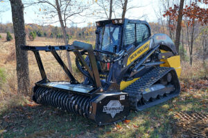 A skid steer with a mulching head used to perform forestry mulching to clear land and remove unwanted plants.